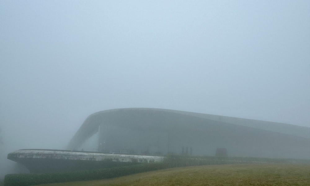 a foggy field with a building in the background