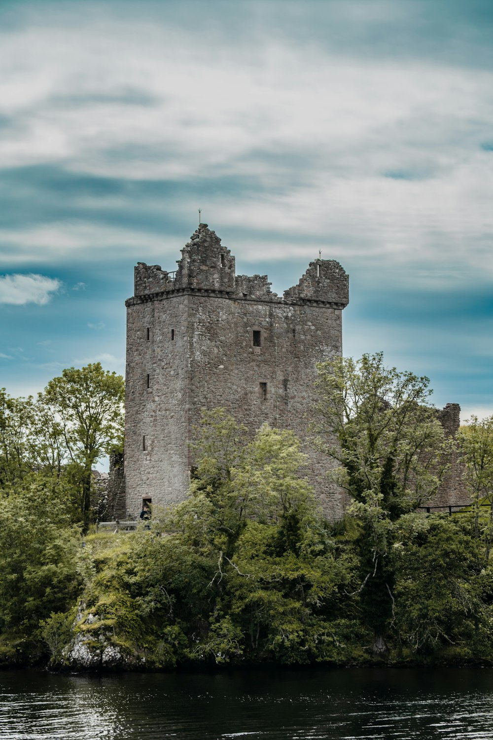 a castle sitting on top of a lush green hillside