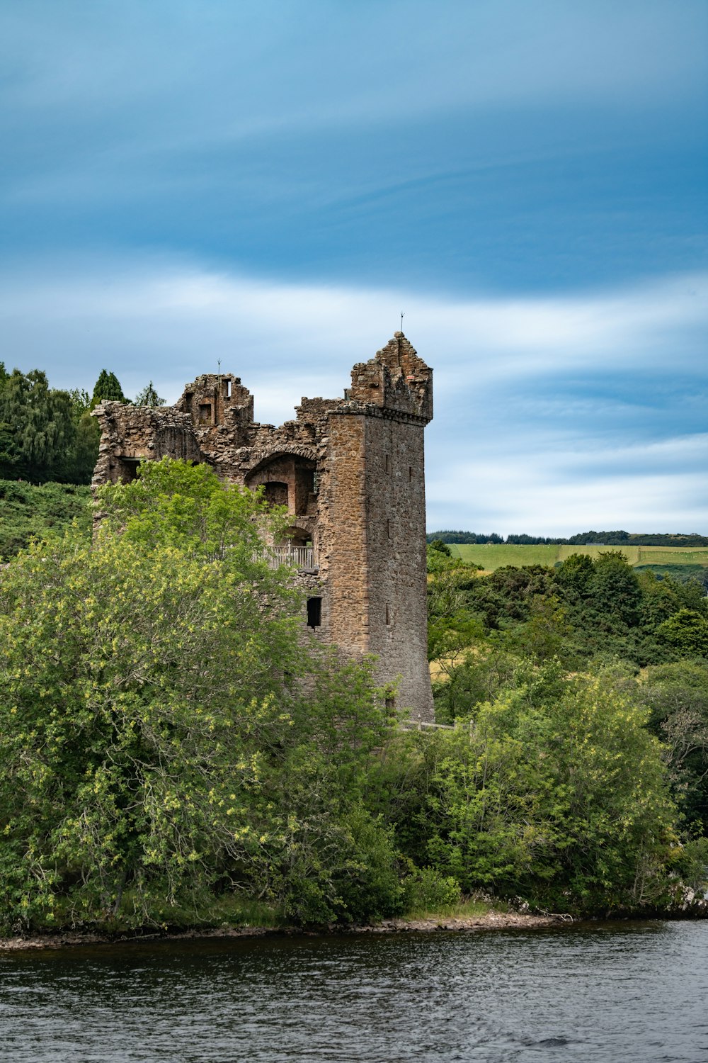a castle sitting on top of a lush green hillside