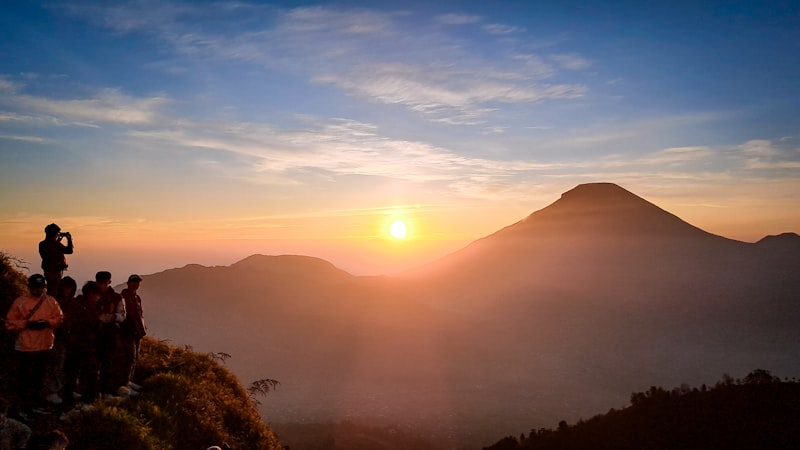 pendaki menikmati sunrise di puncak gunung prau