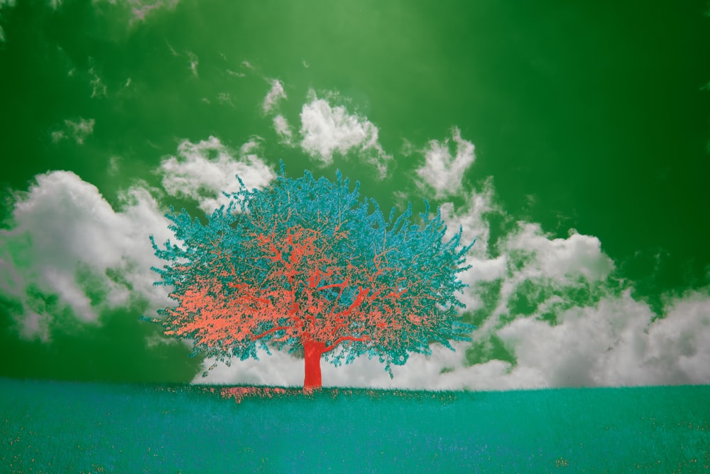a tree with blue and red leaves in a green field