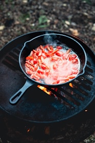 a frying pan filled with food on top of a grill