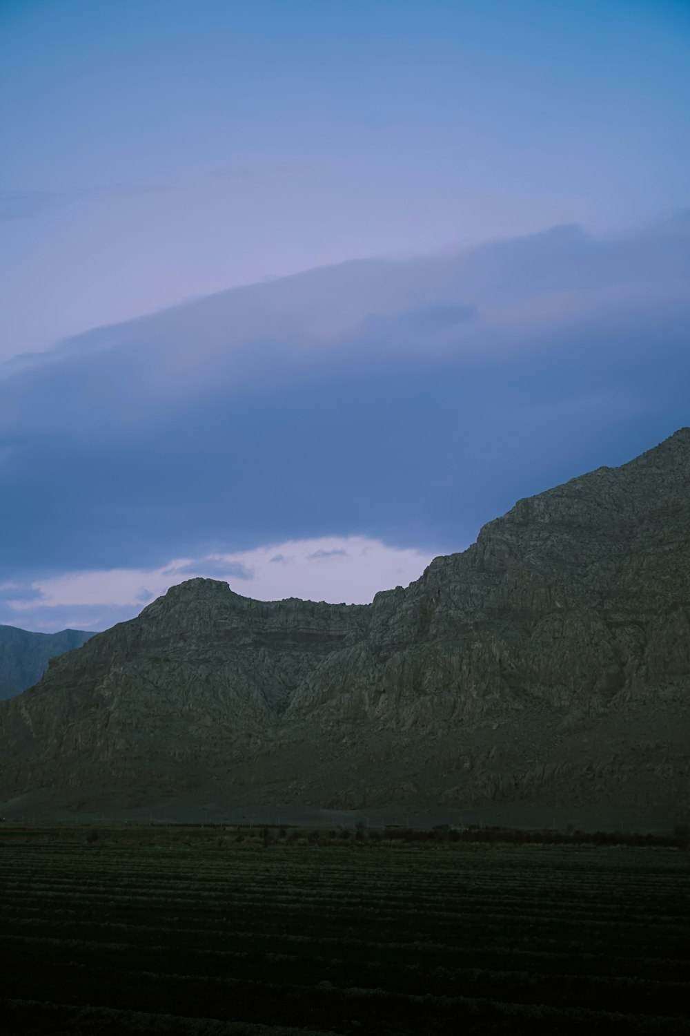 a mountain with a few clouds in the sky