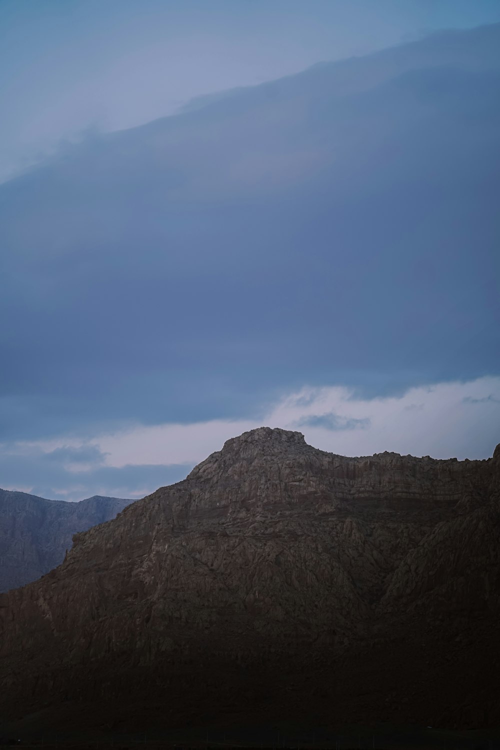 a mountain with a few clouds in the sky