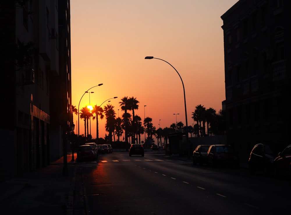 the sun is setting over a city street