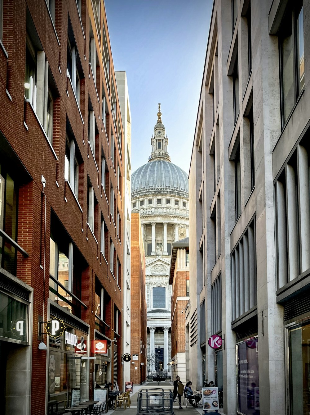 a city street with a domed building in the background