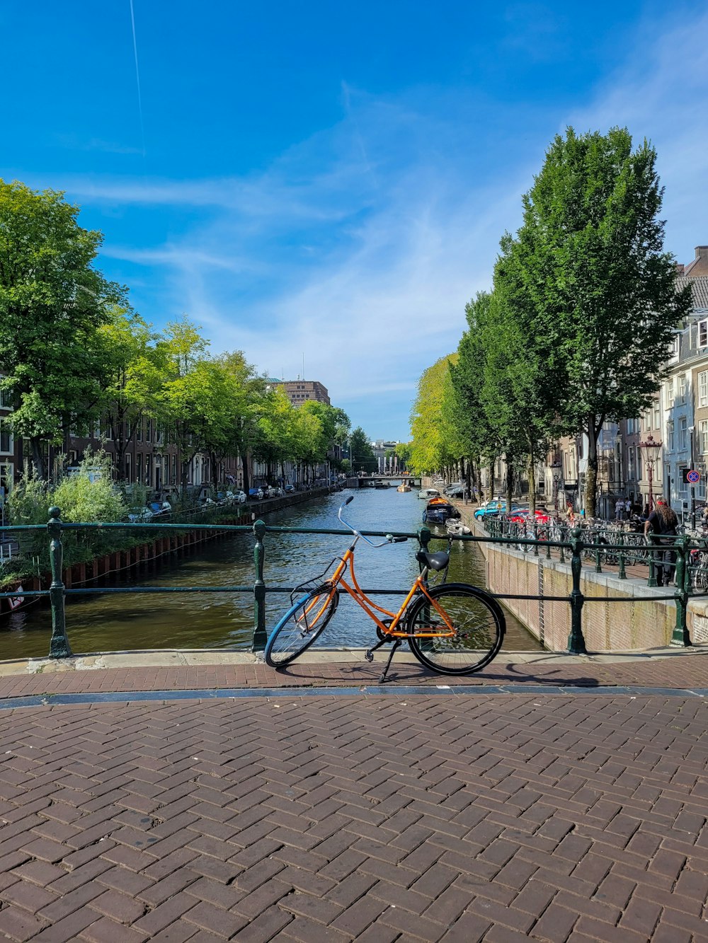 a bicycle parked on the side of a brick road