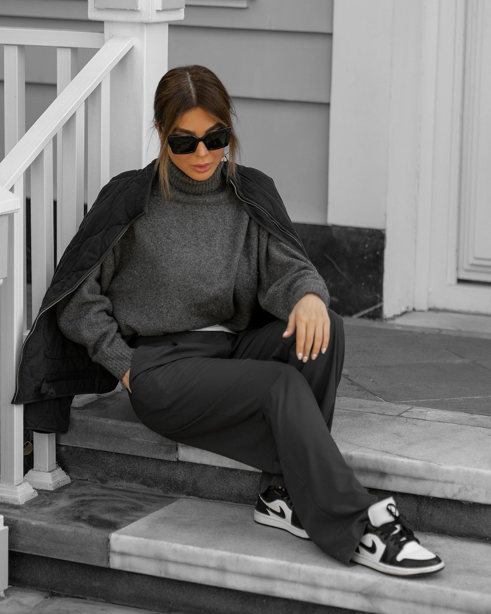 a woman sitting on the steps of a house