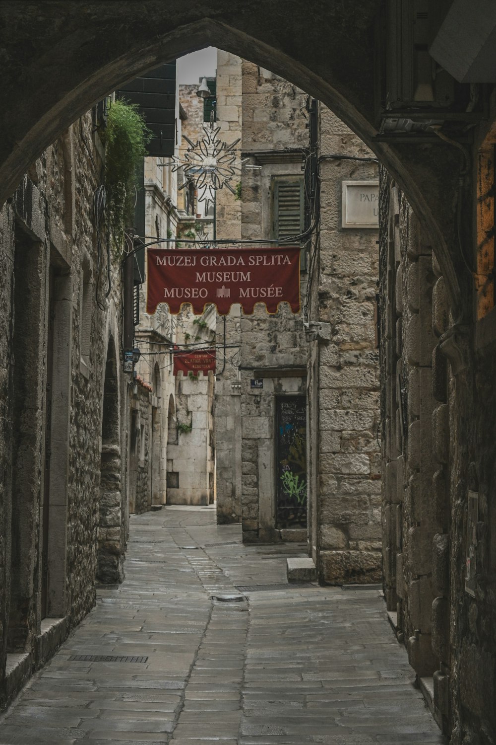 a narrow alley way with a sign on it
