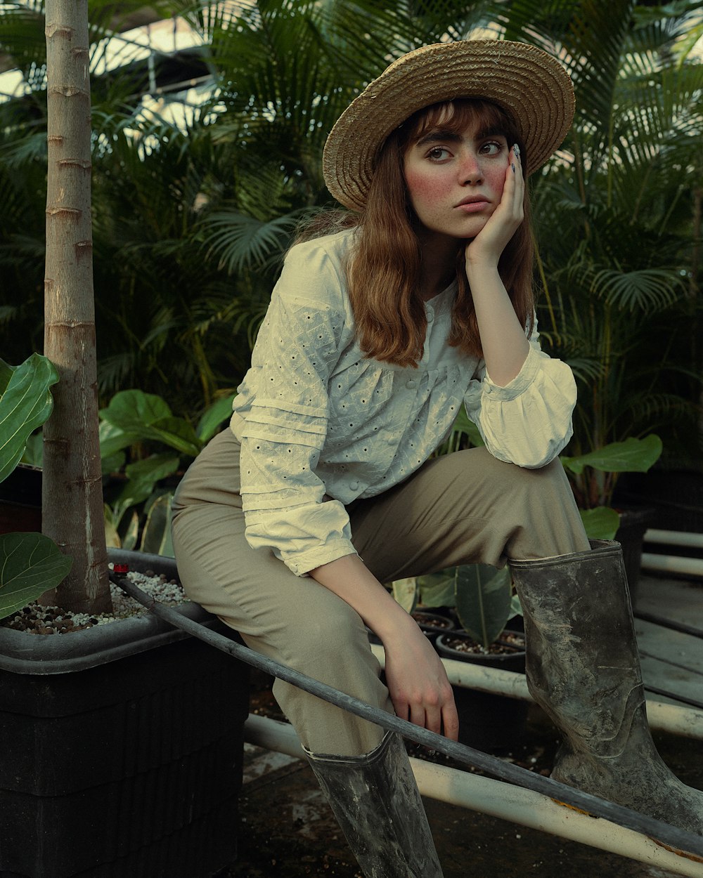 a woman in a hat is sitting on a bench