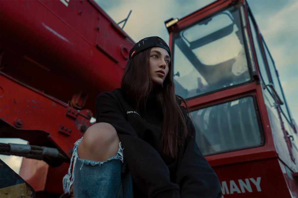 a woman standing in front of a red truck