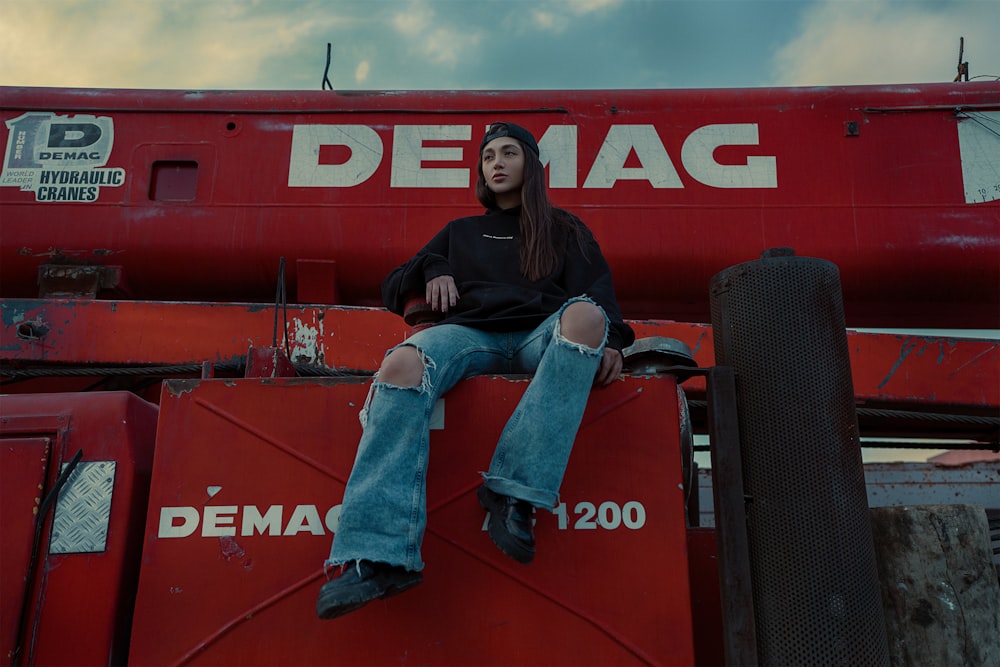 a woman sitting on the back of a red truck