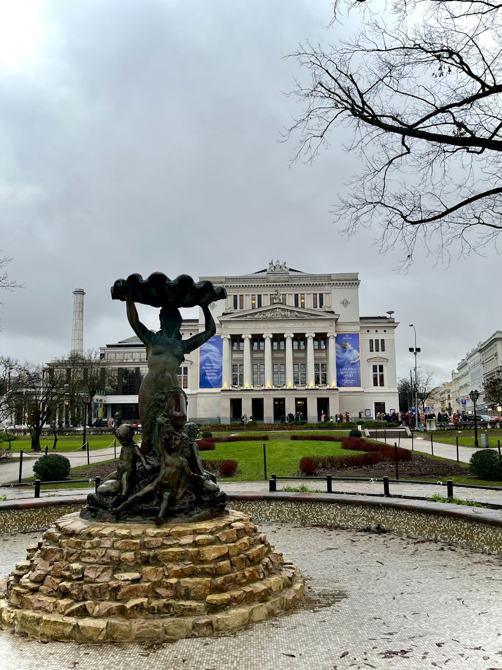 a statue of a woman holding a basket in front of a building