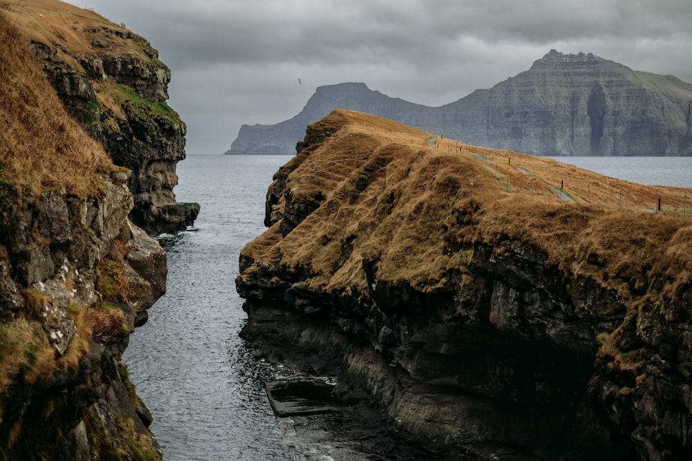 a body of water surrounded by mountains and grass