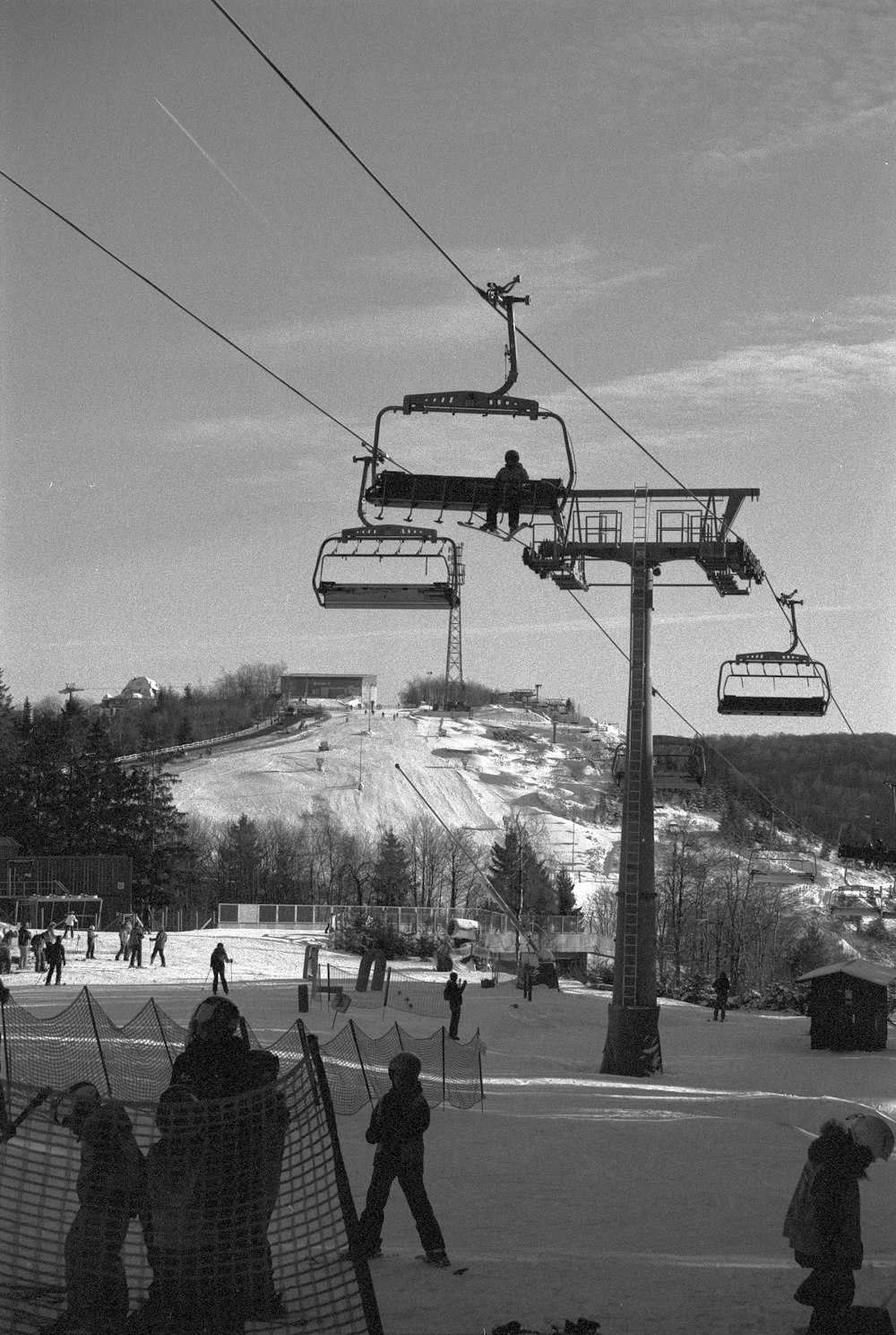 a ski lift carrying skiers up a snowy hill