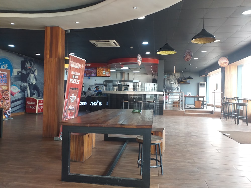 a restaurant with a large wooden table in the middle of the room