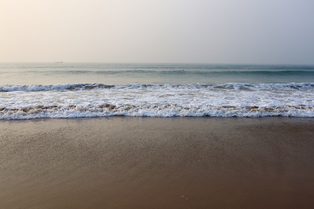 una spiaggia con le onde che arrivano a riva