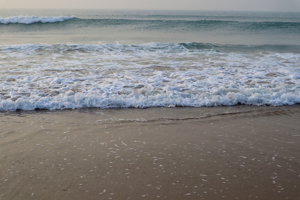 una spiaggia con onde che entrano ed escono dall'acqua