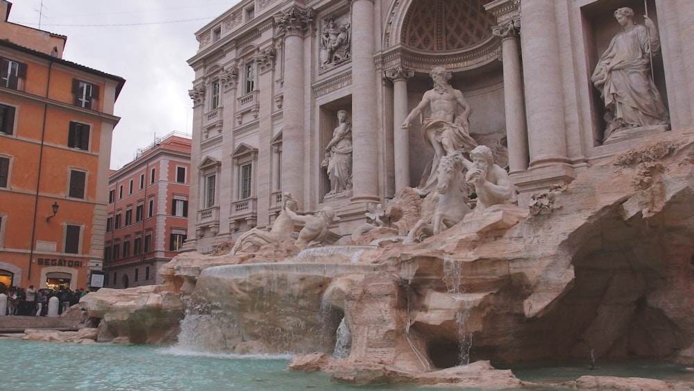 a group of people standing around a fountain