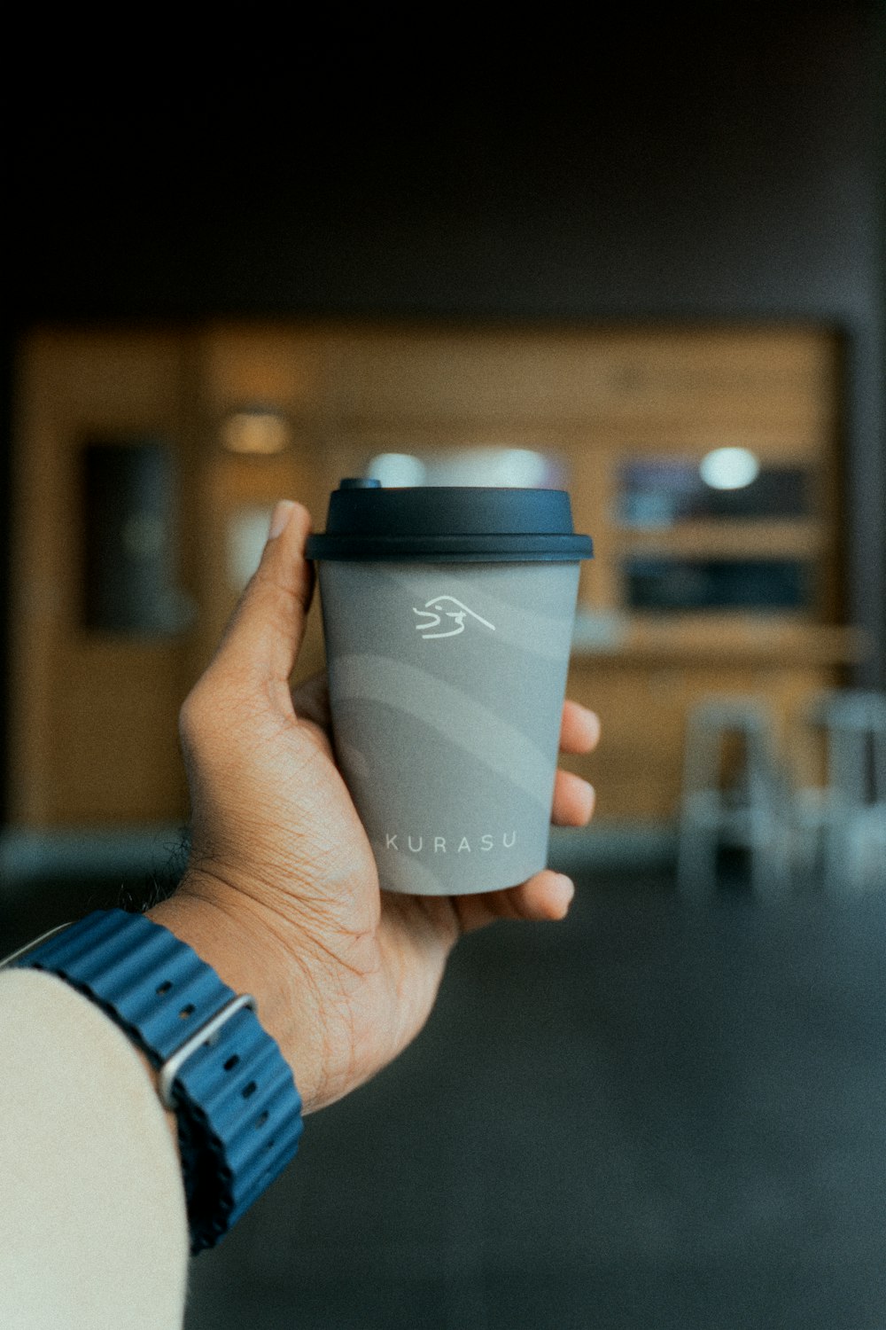 eine Person, die eine Tasse Kaffee in der Hand hält