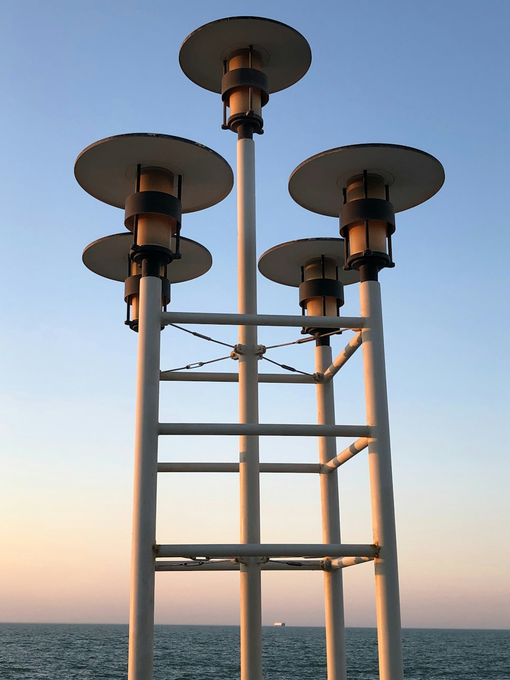 a row of street lights sitting next to the ocean