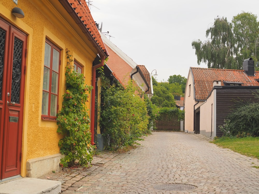 Eine Kopfsteinpflasterstraße, die von gelben Gebäuden gesäumt ist