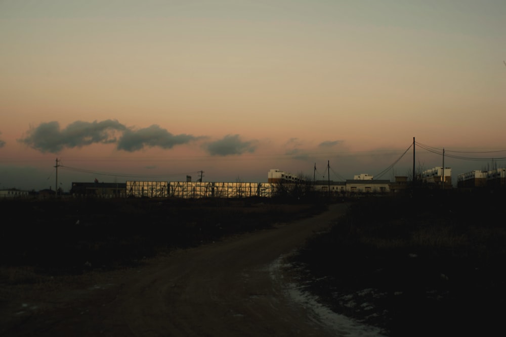 a train traveling down tracks next to a dirt road