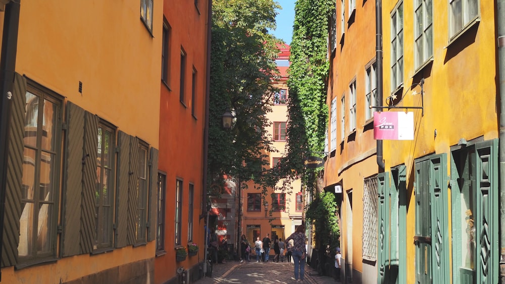 a narrow city street lined with yellow buildings