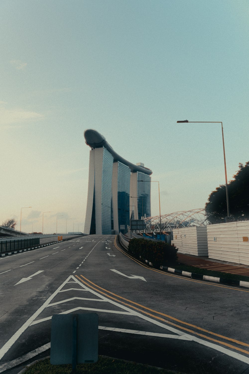 an empty street with a large building in the background