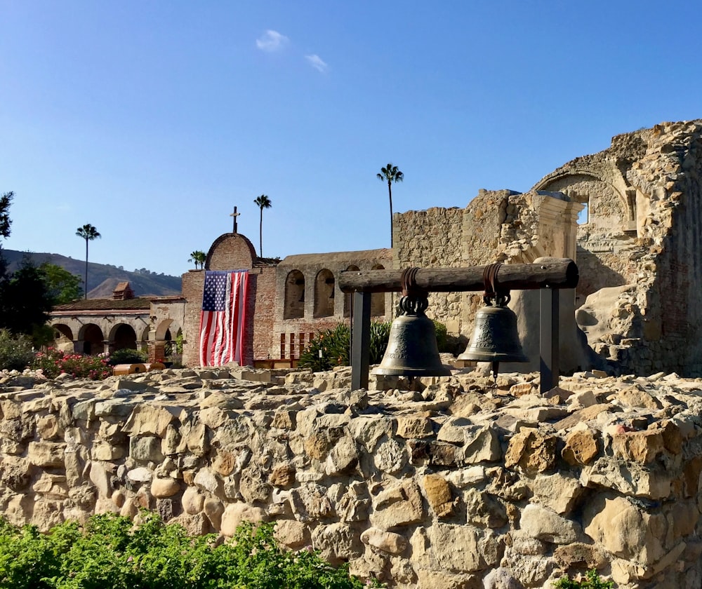 a stone wall with a bell on top of it