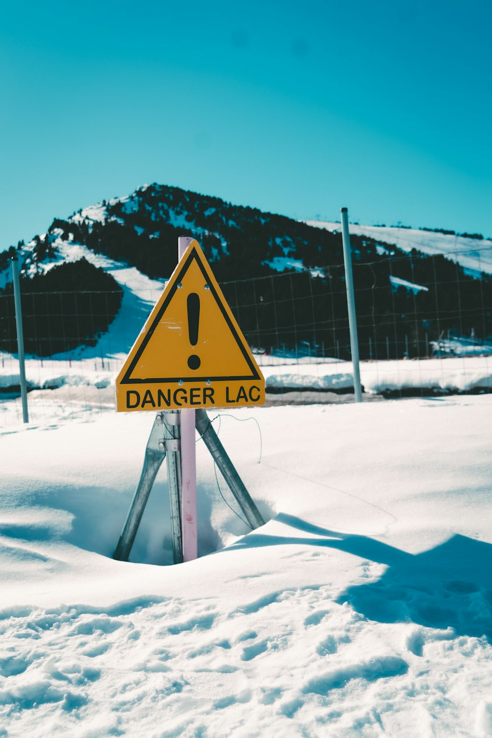 a warning sign in the middle of a snowy field