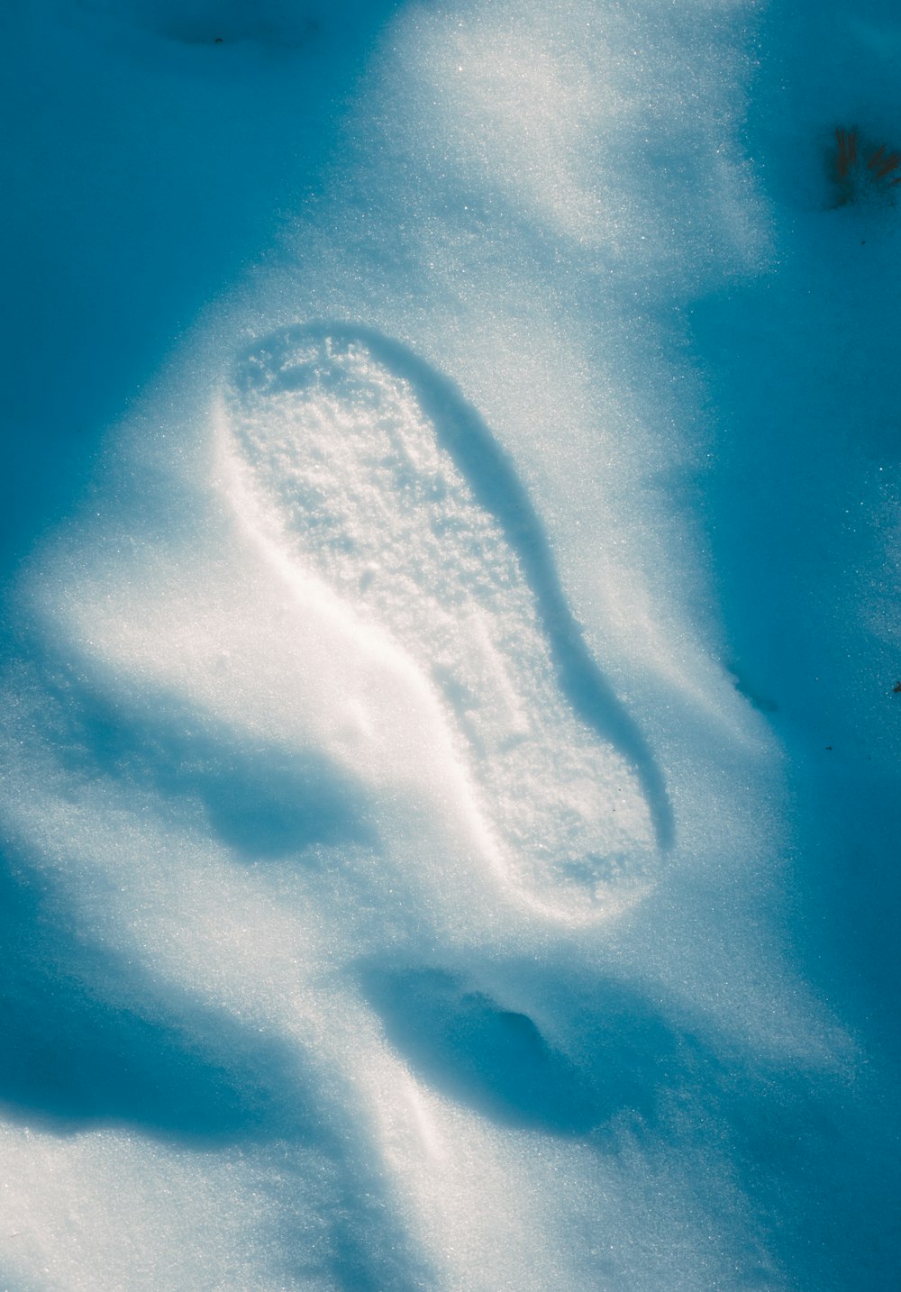 a snow covered ground with a snow shoe imprint in the snow