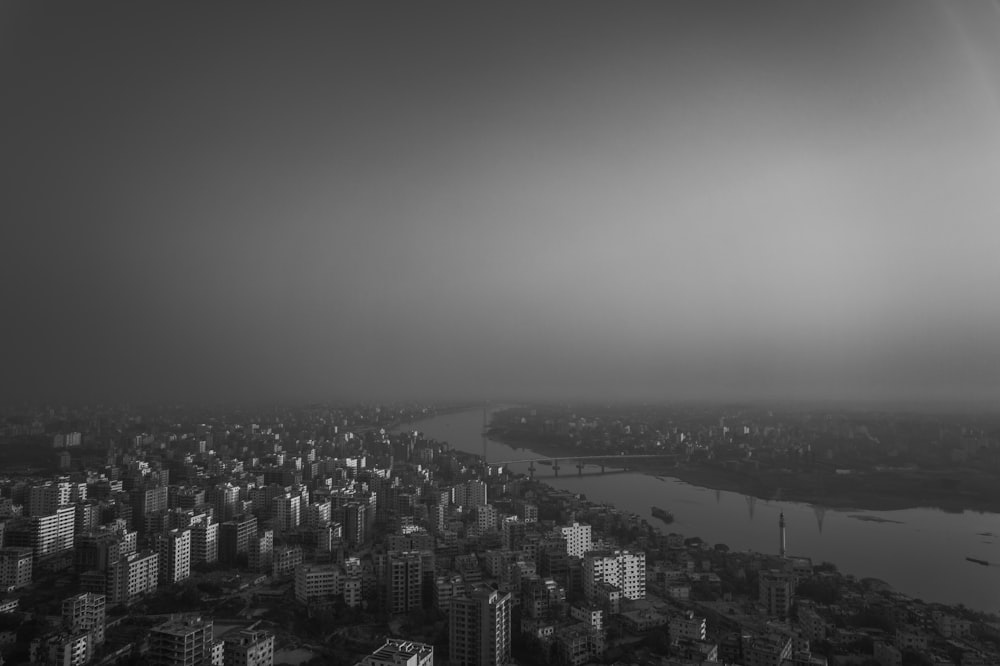a black and white photo of a city and a river