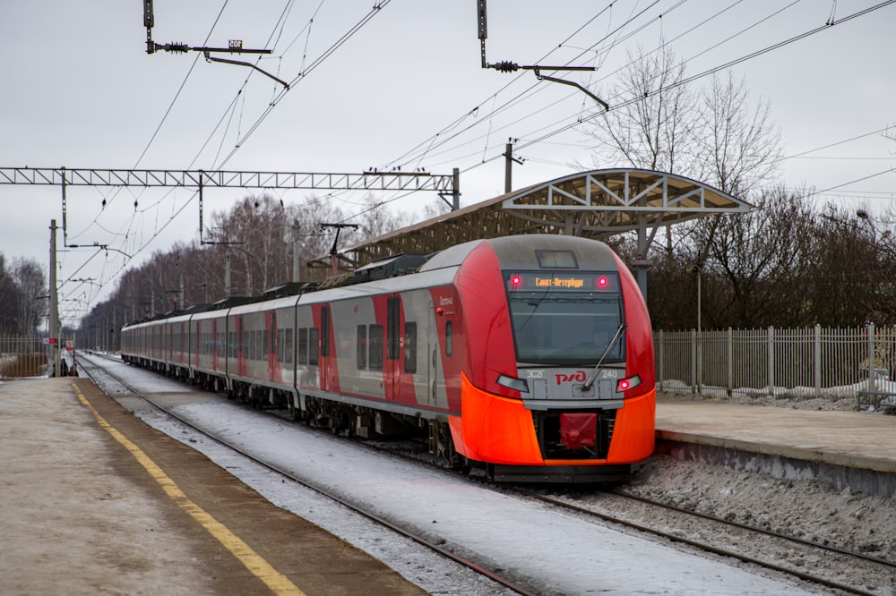 a red and silver train traveling down train tracks