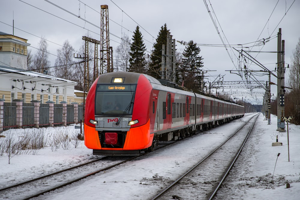 a red and silver train traveling down train tracks