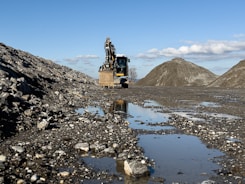 a dump truck driving down a muddy road