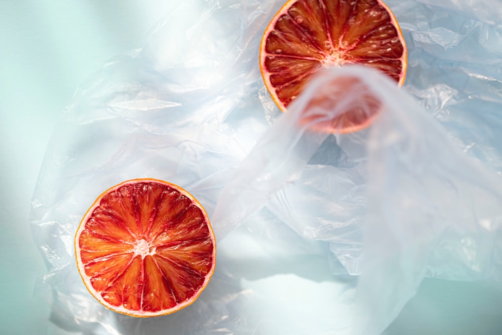 a grapefruit cut in half sitting on top of a plastic bag