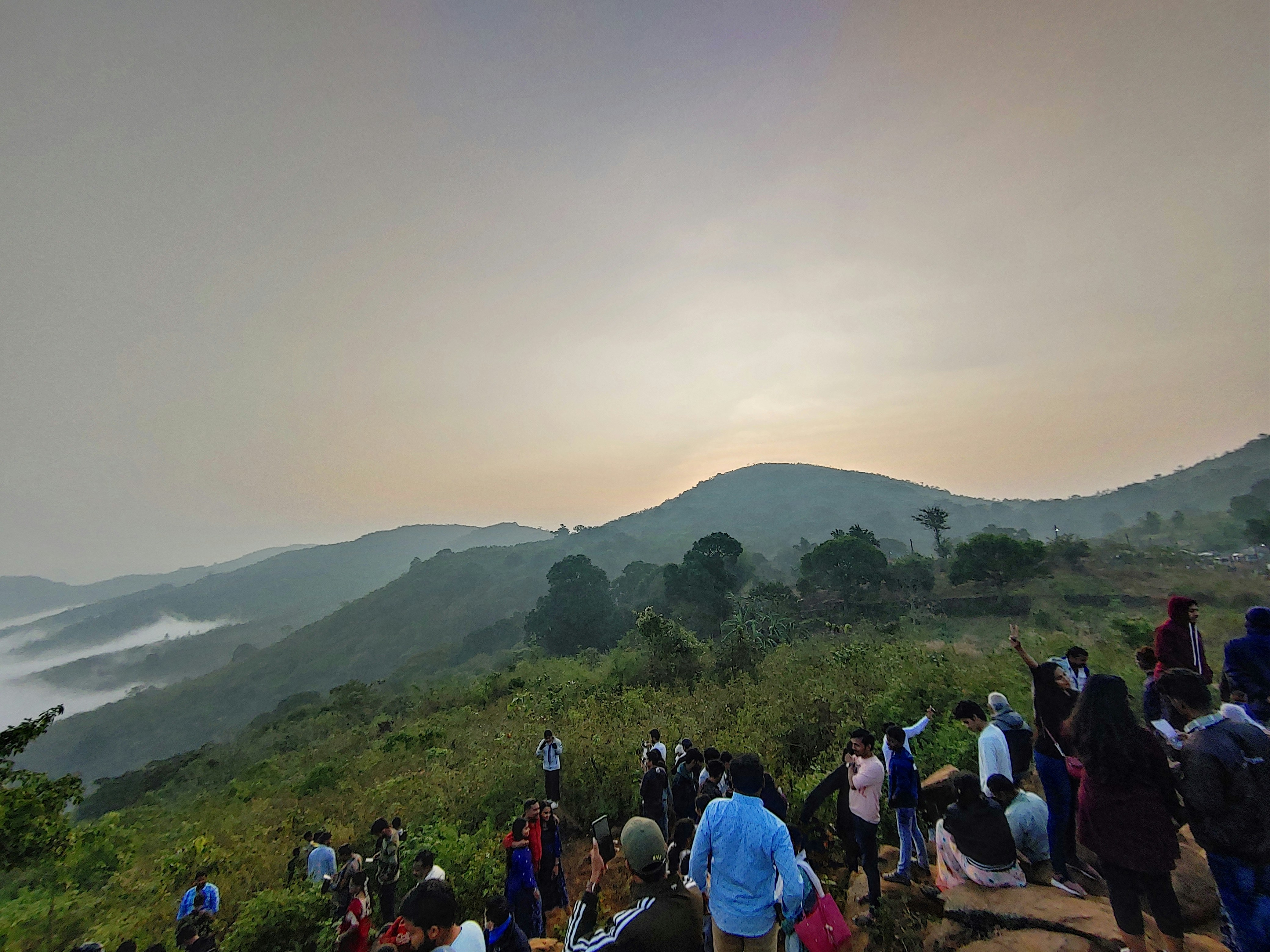 A group of people standing on top of a lush green hillside photo – Free ...