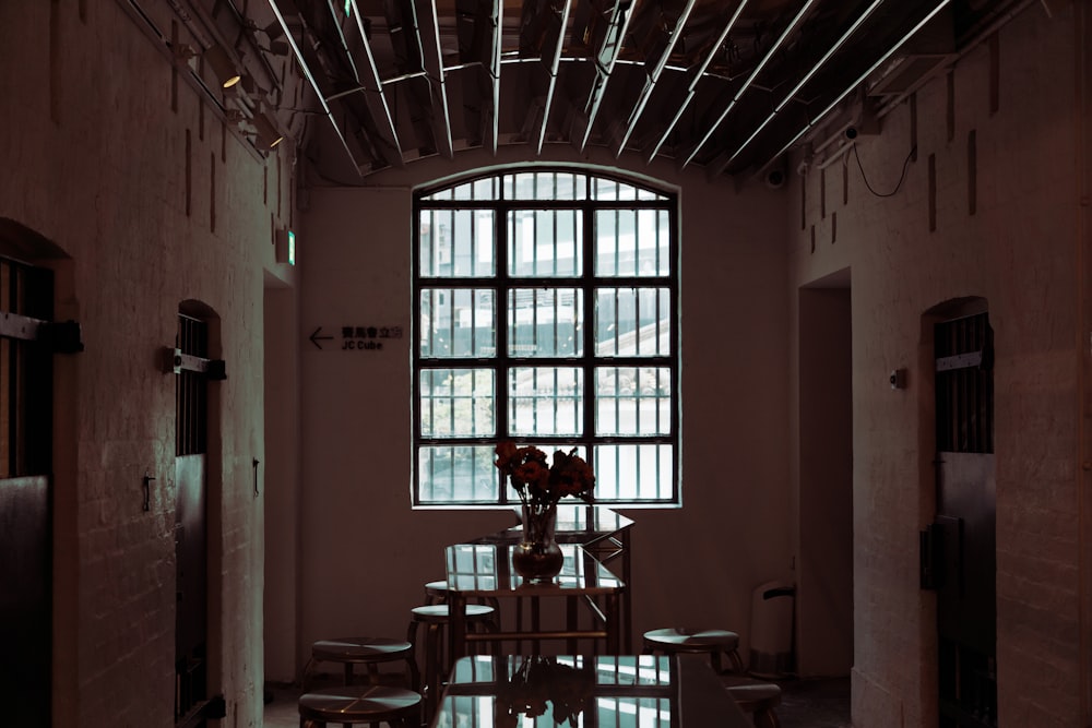 a room with a table and chairs and a large window