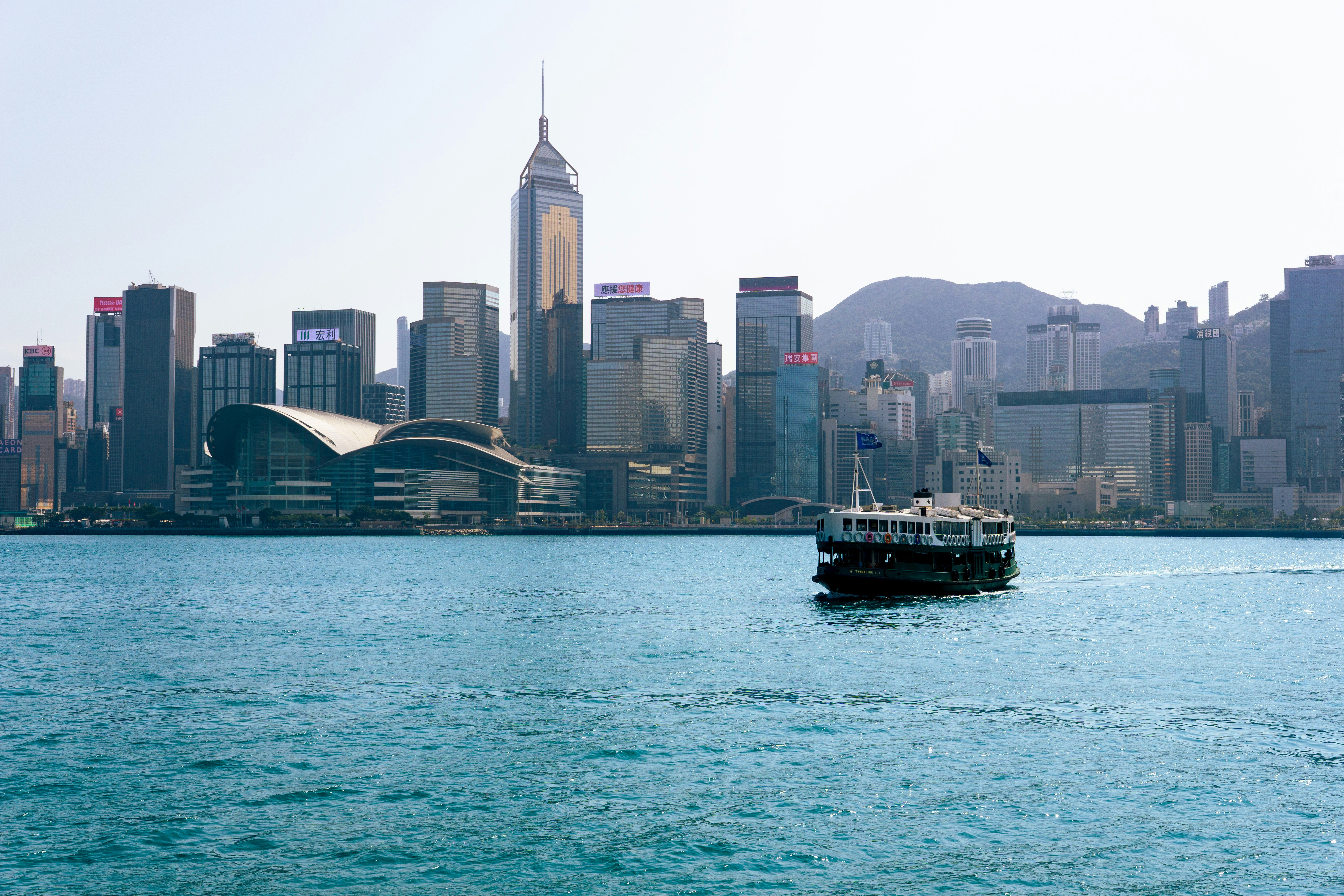 a boat in a large body of water with a city in the background, 