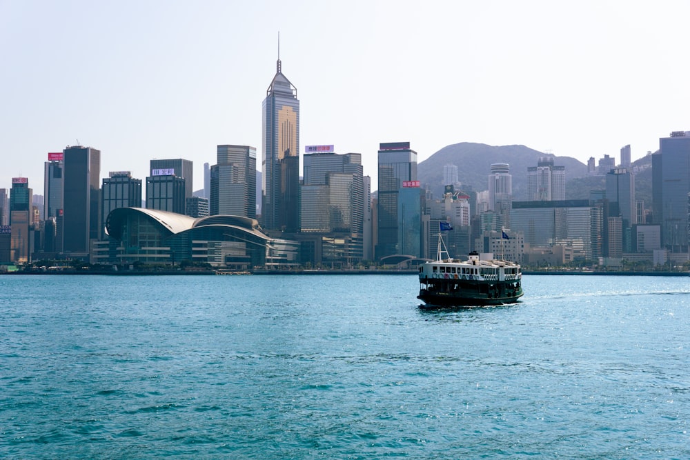 a boat in a large body of water with a city in the background