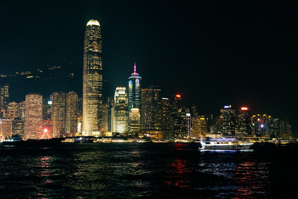 a city skyline at night with a boat in the water