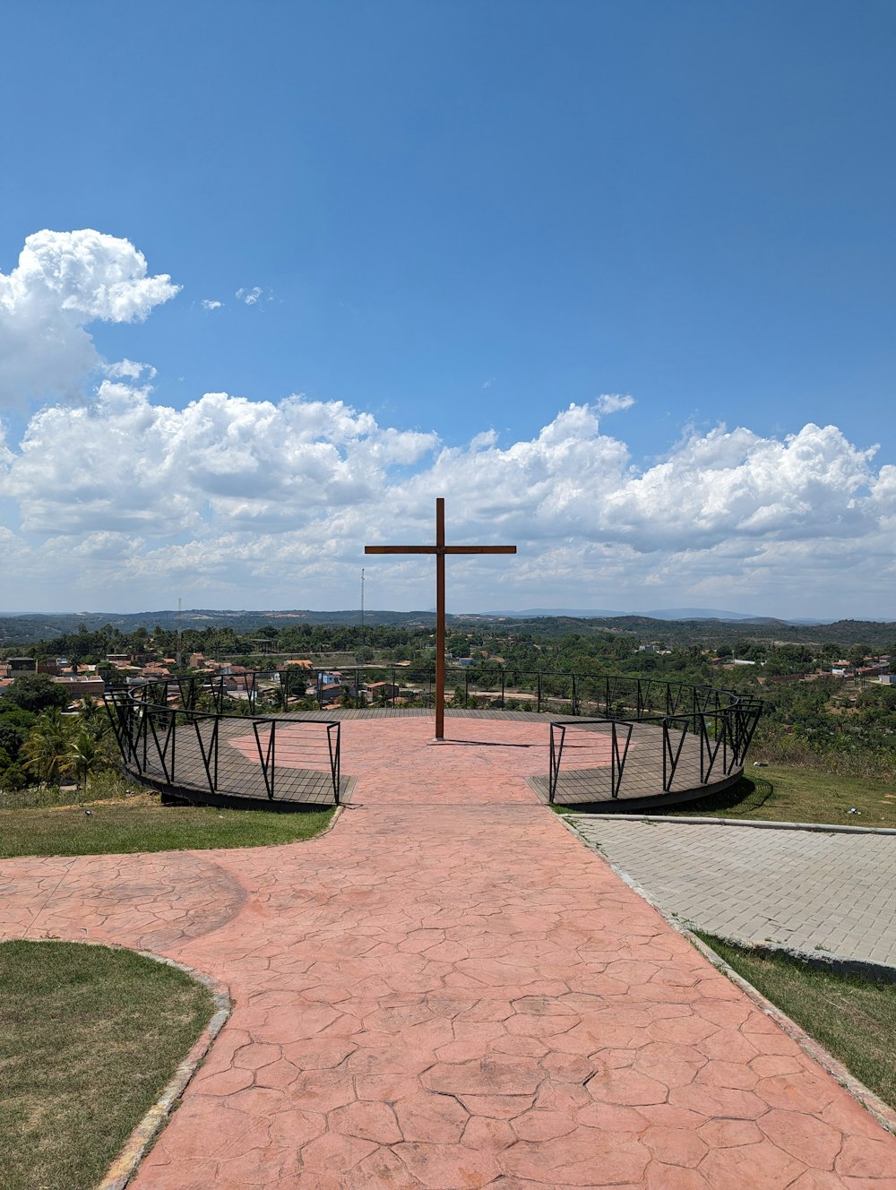 a cross on top of a hill with a sky background