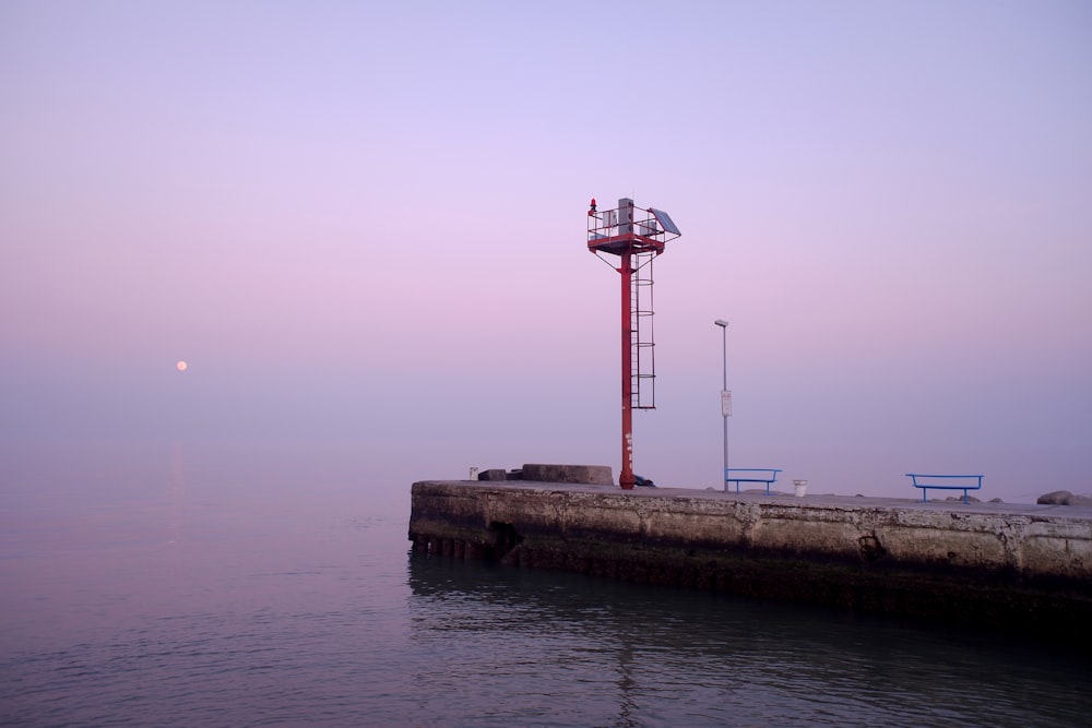 a light tower sitting on top of a pier next to the ocean