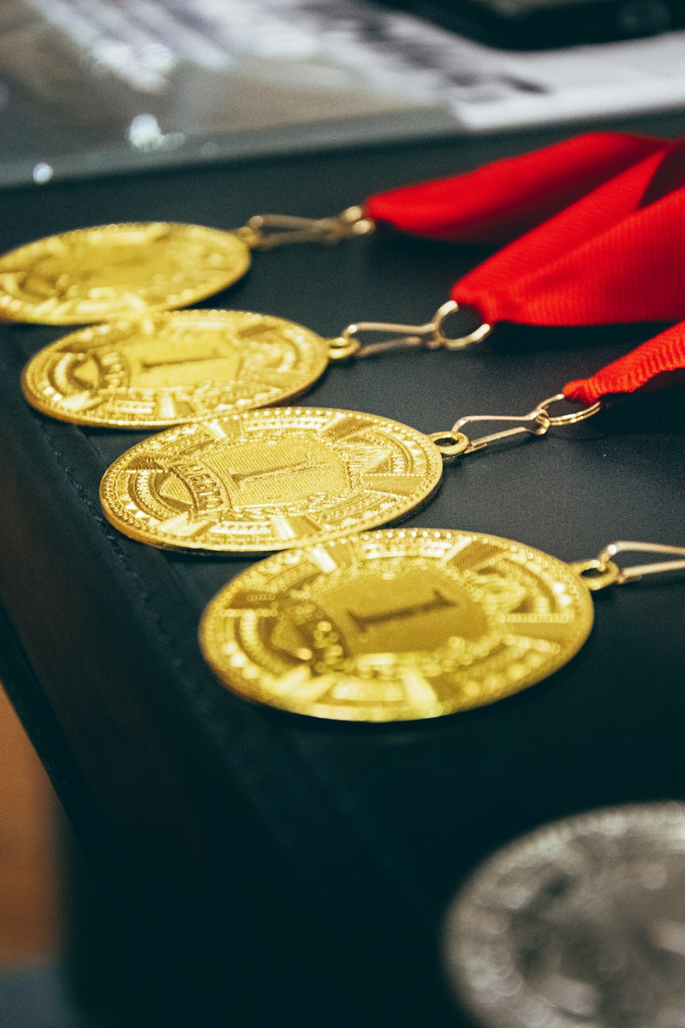 a row of gold medals with a red ribbon