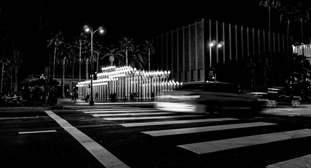 a black and white photo of a street at night