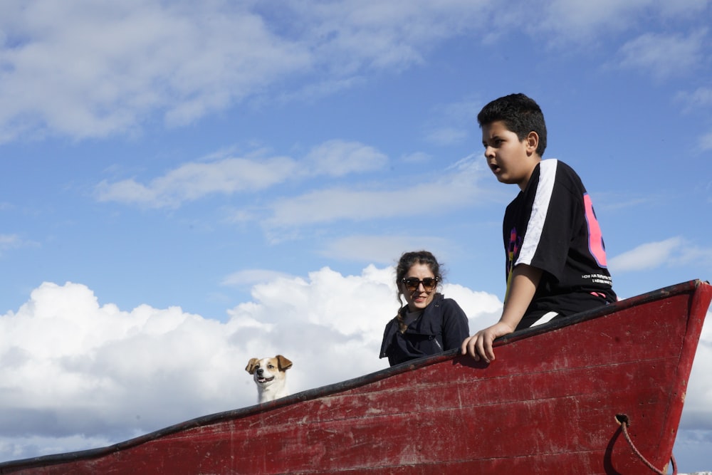 a boy and a girl on a boat with a dog