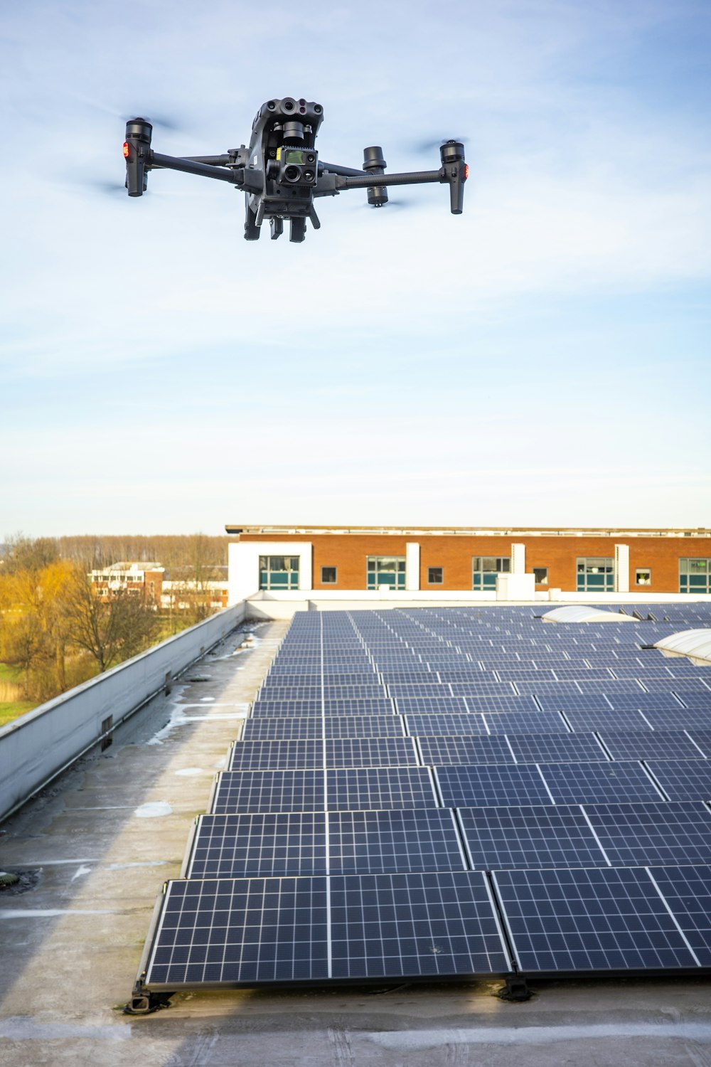 a large black object flying over a building