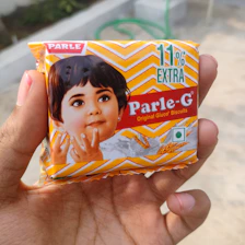 a hand holding a package of parle - g powder