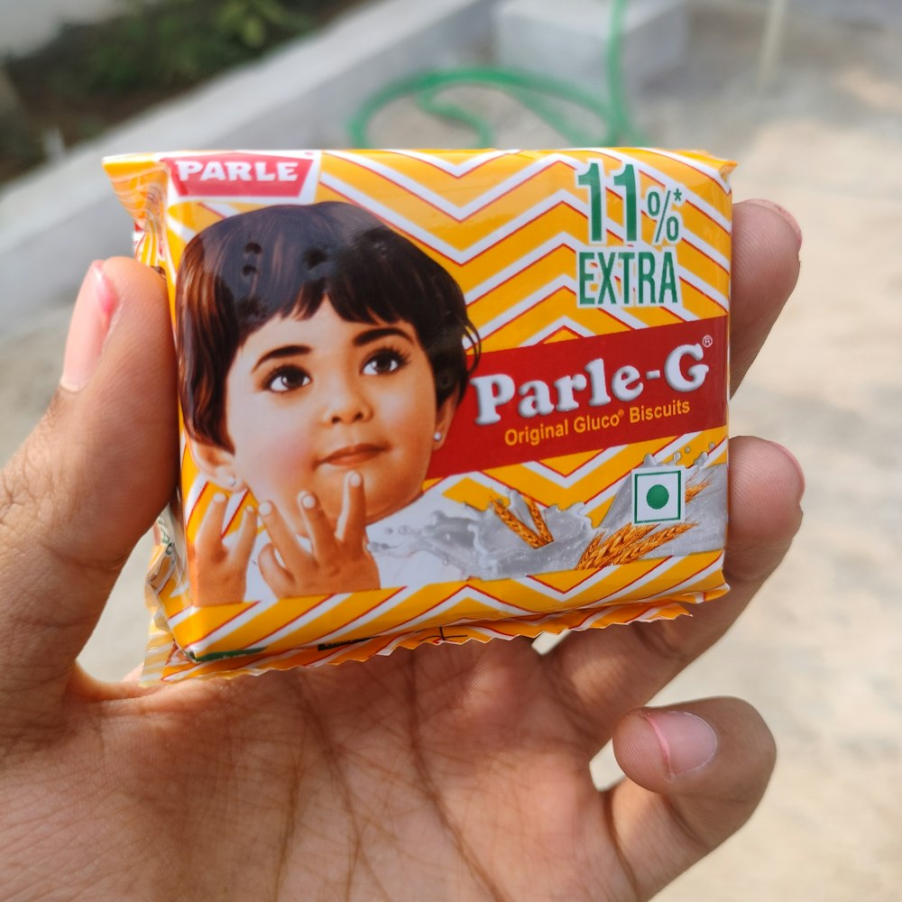 a hand holding a package of parle - g powder